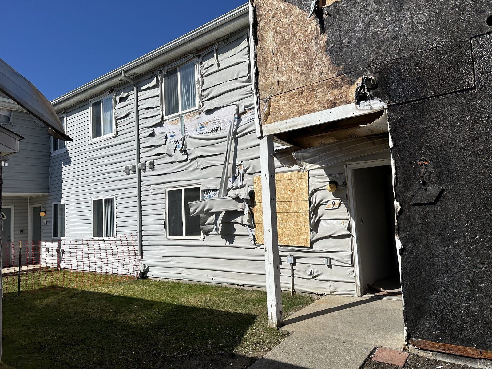 Charred siding and structural fire damage on a multi-unit residential building