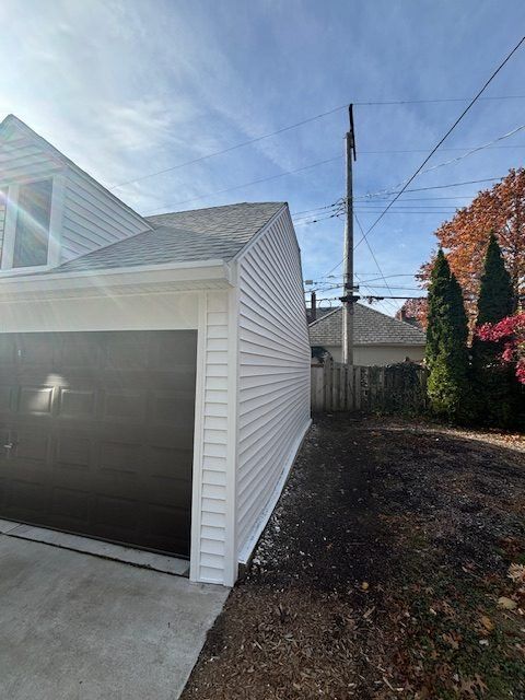 Restored detached garage with new siding after storm damage repair