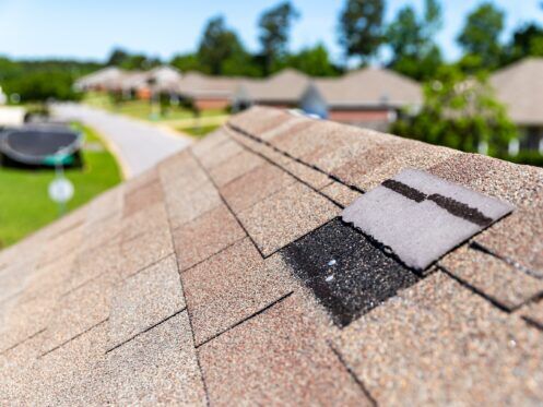 Missing shingles on roof due to storm damage.
