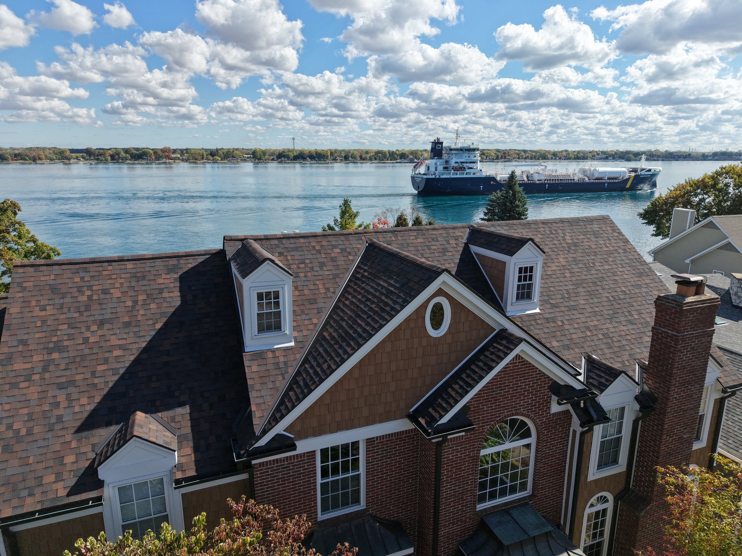 Aerial view of the St. Clair River with a freighter passing waterfront homes in the Blue Water Area near Port Huron, Michigan