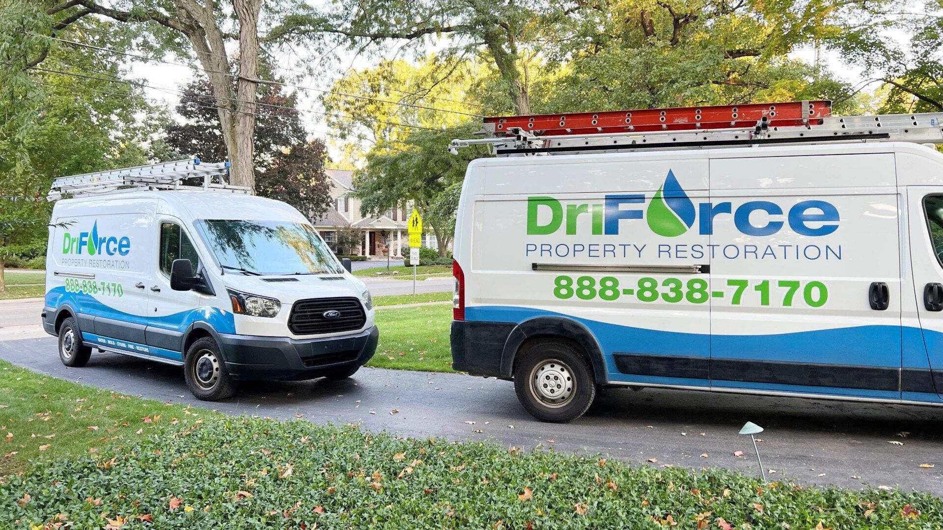 DriForce Property Restoration vans parked on a tree-lined residential street in Oakland County, Michigan