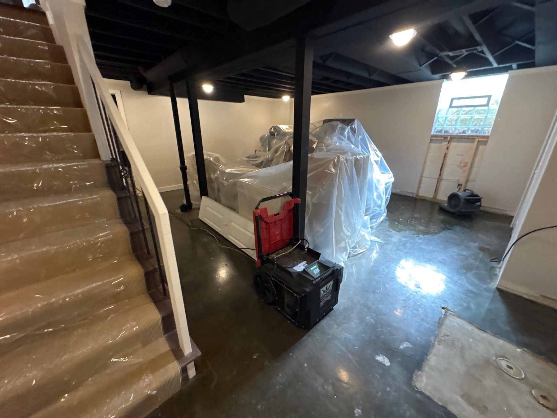 Household contents wrapped and protected during a water loss in a Metro Detroit home basement